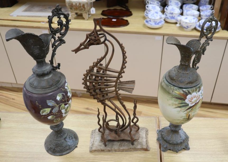 A wrought iron sea horse sculpture, 58cm and two spelter and enamelled glass ewers, 56cm